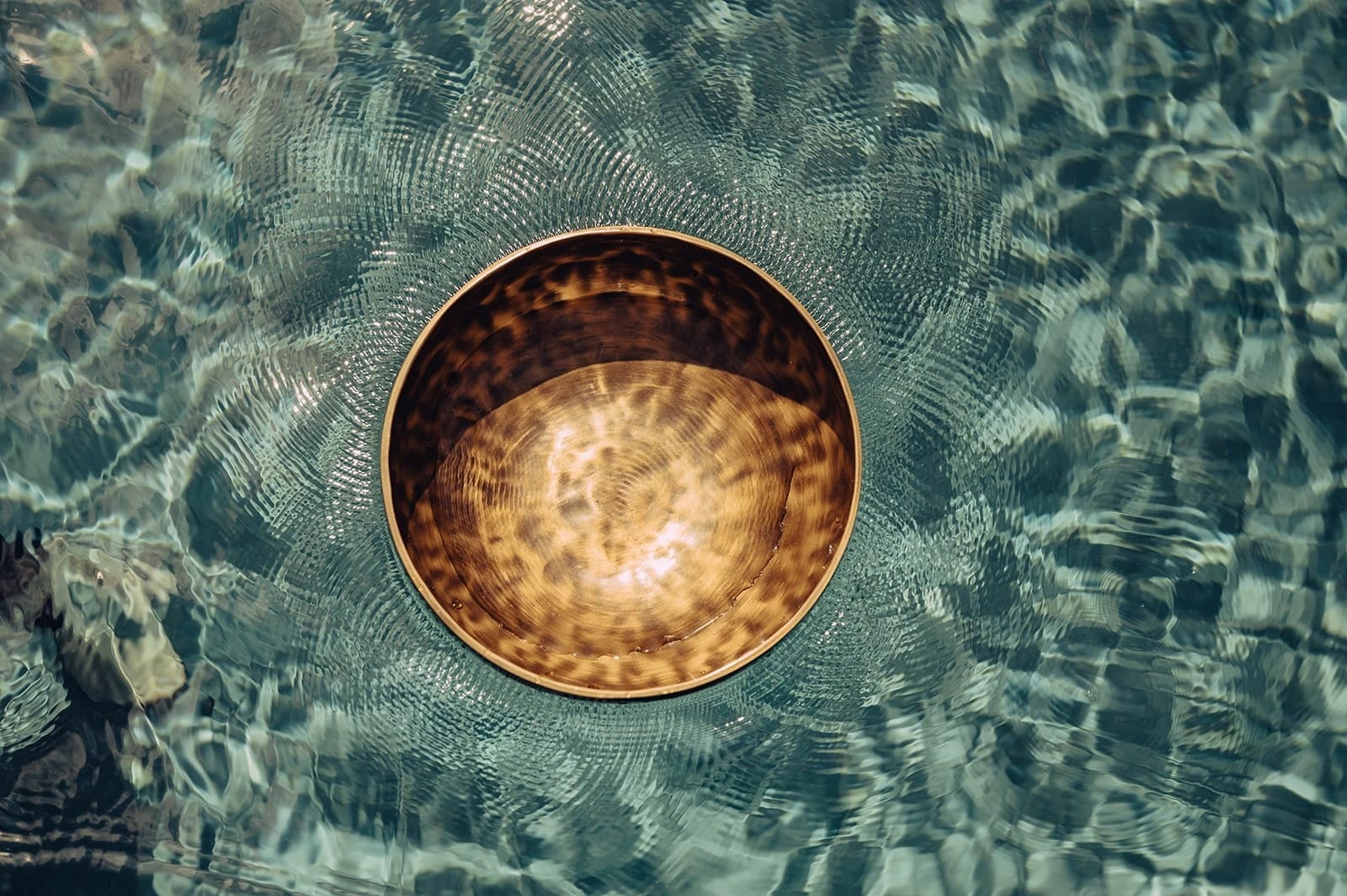 Klangschale schwimmt auf türkisem Wasser